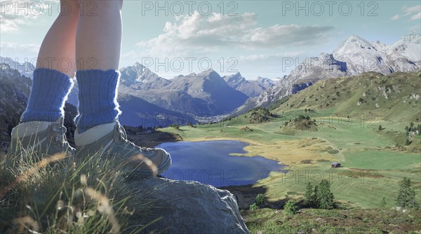 Legs of Caucasian woman standing on rock over valley lake