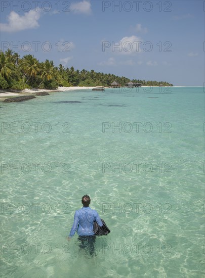 Caucasian businessman walking in ocean