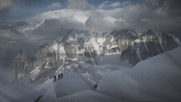 Caucasian men hiking on mountain in winter