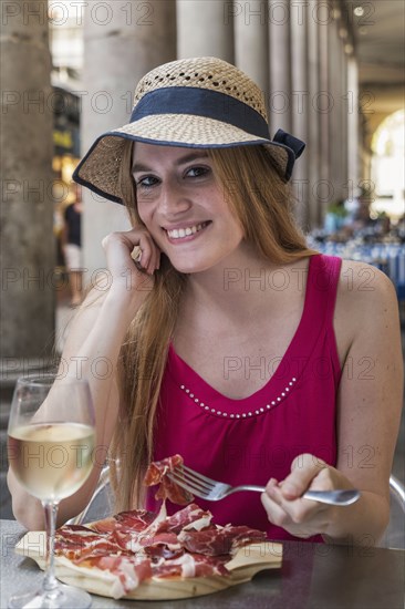 Portrait of smiling Caucasian woman eating meat at restaurant
