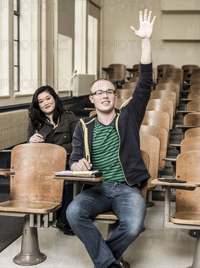 Student raising his hand in classroom