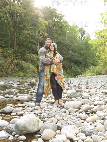 Couple hugging near stream