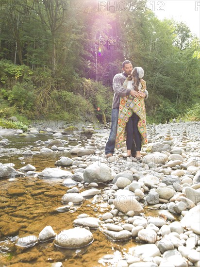 Couple hugging near stream