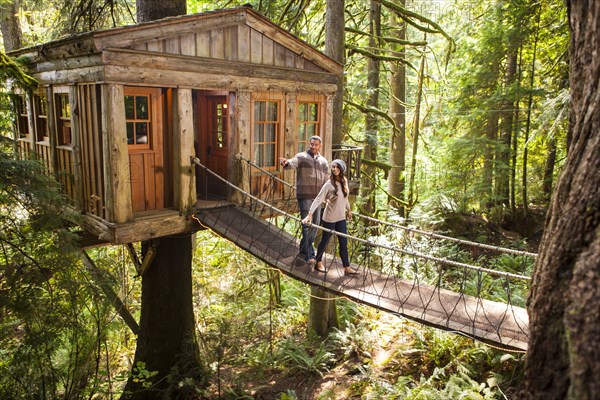 Couple on walkway of remote tree house