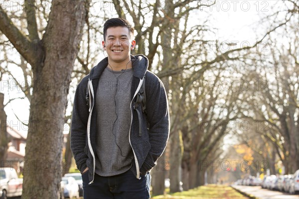 Mixed race man walking on suburban street