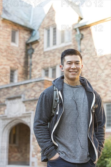 Mixed race college student listening to music on headphones