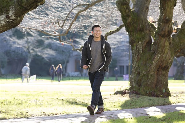 Mixed race college student walking on campus