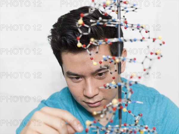 Mixed race student working on double helix model