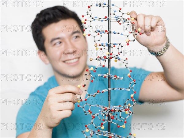 Mixed race student working on double helix model