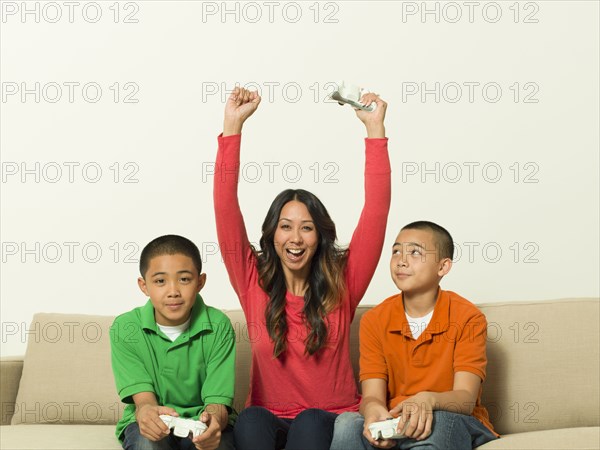 Mother and sons playing video games together