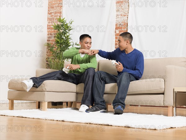 Mixed race brothers playing video games together