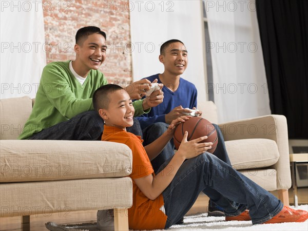 Mixed race brothers playing video games together