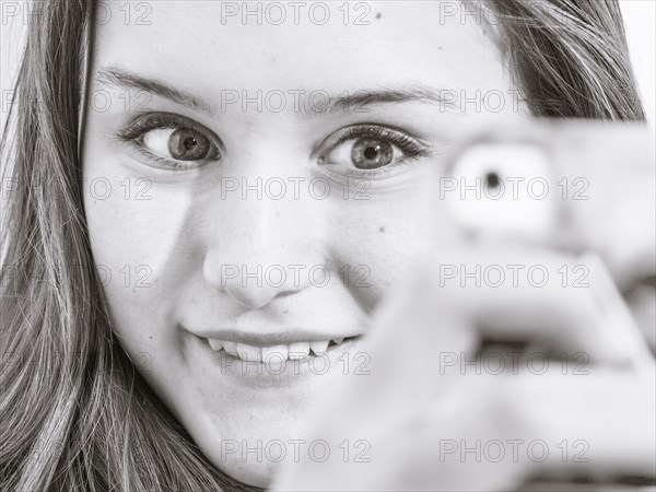 Caucasian teenage girl taking picture with cell phone