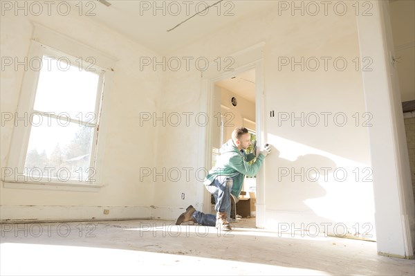 Mixed race carpenter working on doorway