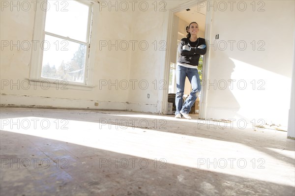 Mixed race woman standing in new home