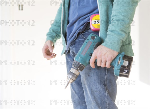 Mixed race carpenter holding power drill