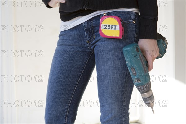 Mixed race woman holding power drill