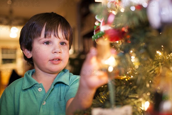 Caucasian boy decorating Christmas tree