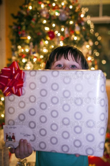 Caucasian boy holding Christmas gift