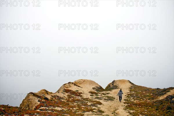 Caucasian woman walking on sand dunes