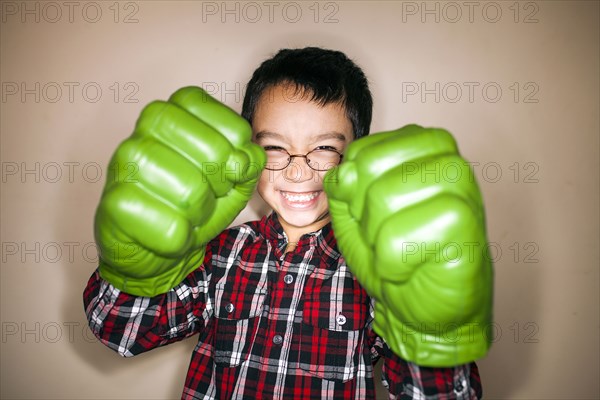 Mixed race boy playing with toy boxing gloves