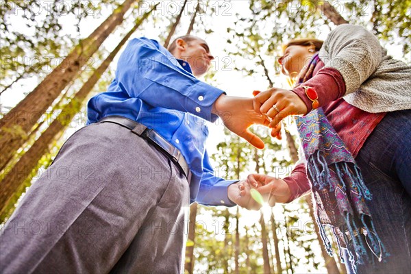 Hispanic couple holding hands in forest