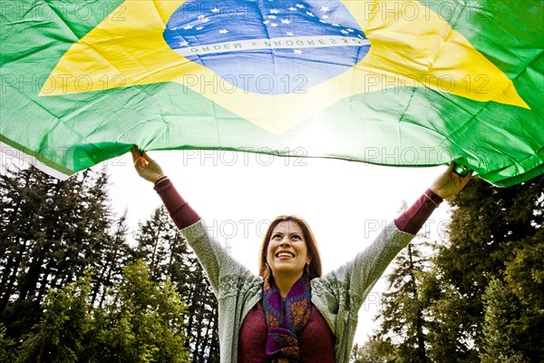 Hispanic woman flying Brazilian flag