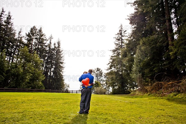 Hispanic couple hugging in park