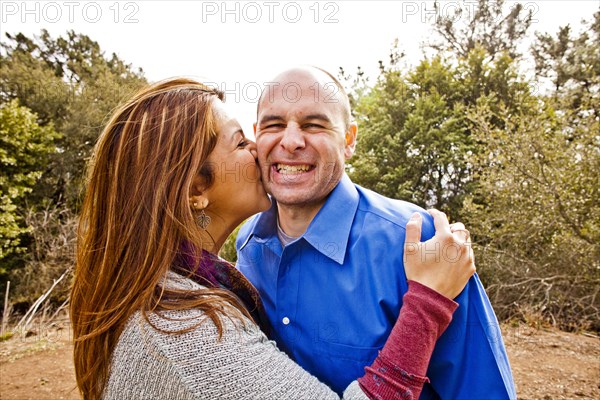 Hispanic couple kissing in park