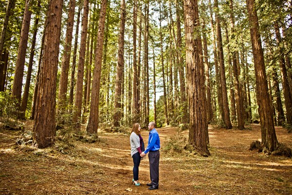 Hispanic couple holding hands in forest