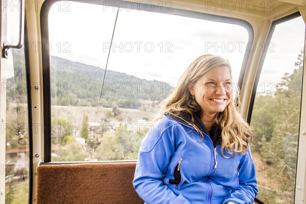 Caucasian woman riding in aerial tram