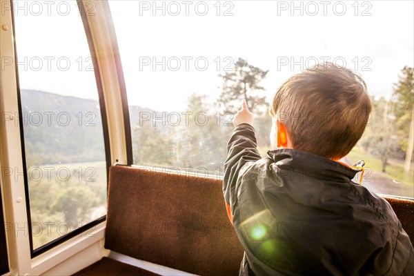 Caucasian boy looking out tram window