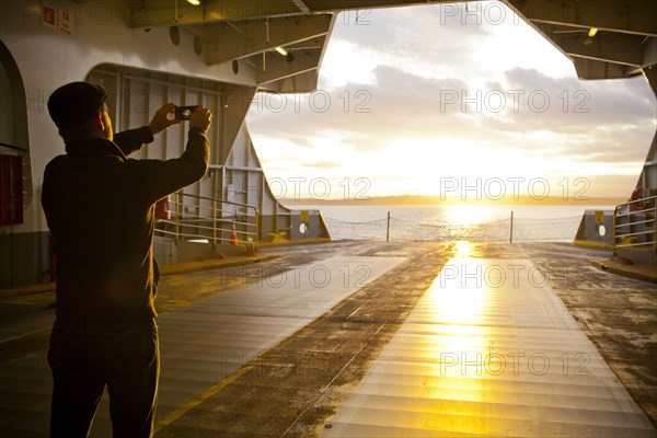 Man taking picture out ferry gate