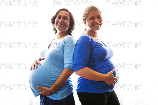 Pregnant women holding their bellies