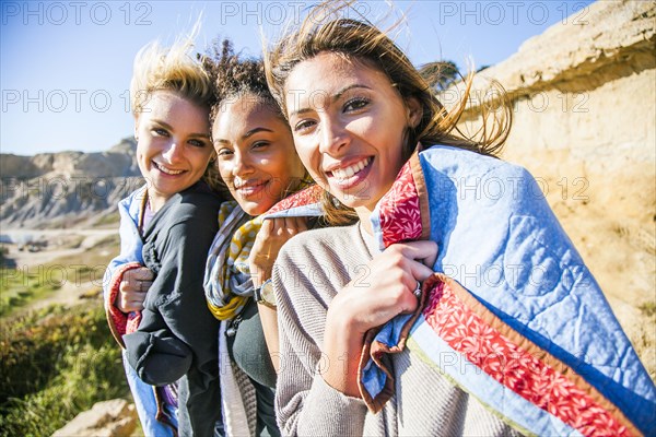 Women wrapped in blanket on rural hillside