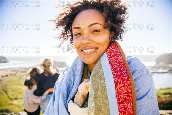 Woman wrapped in blanket on rural hillside