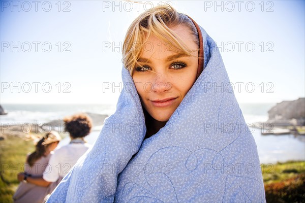 Woman wrapped in blanket on rural hillside