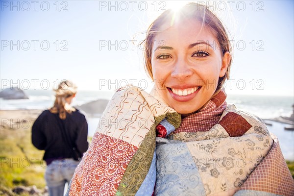Woman wrapped in blanket on rural hillside