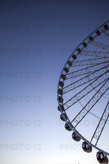 Low angle view of ferris wheel against blue sky