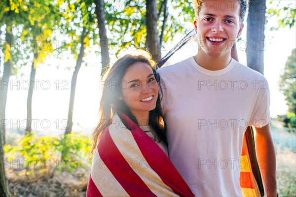 Caucasian couple wrapped in American flag