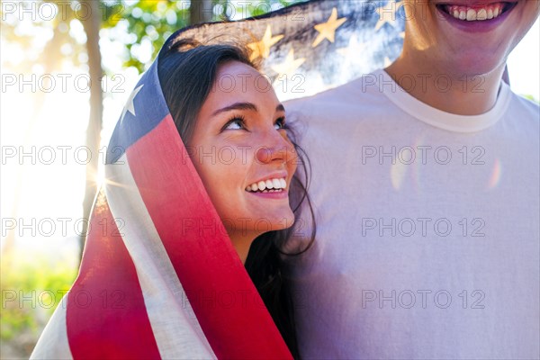 Caucasian couple wrapped in American flag