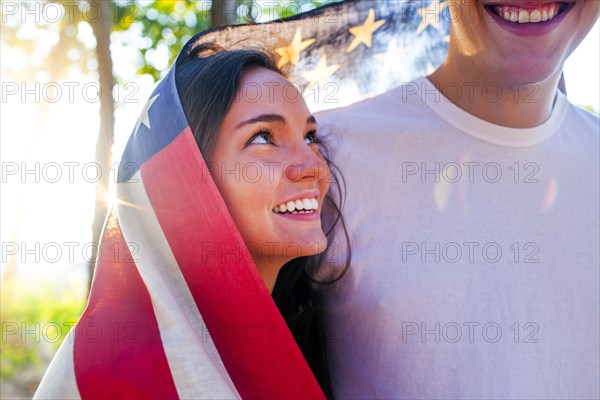 Caucasian couple wrapped in American flag