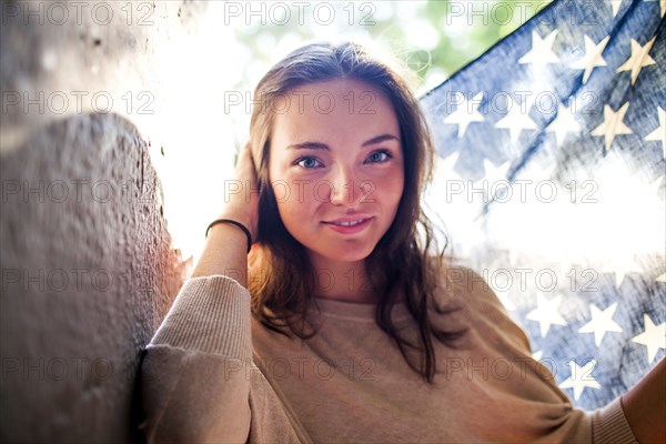 Caucasian woman holding American flag outdoors