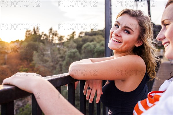 Caucasian teenage girls standing on bridge