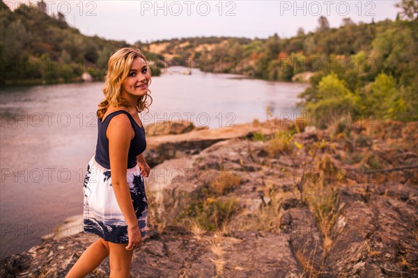 Caucasian teenage girl walking on riverbank