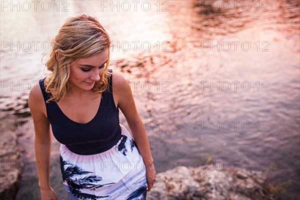 Caucasian teenage girl standing on riverbank