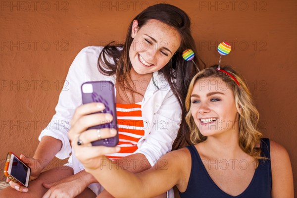 Caucasian teenage girls taking cell phone selfie