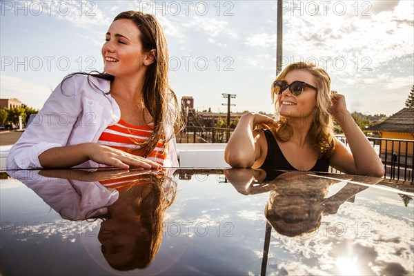 Caucasian teenage girls reflected in car roof