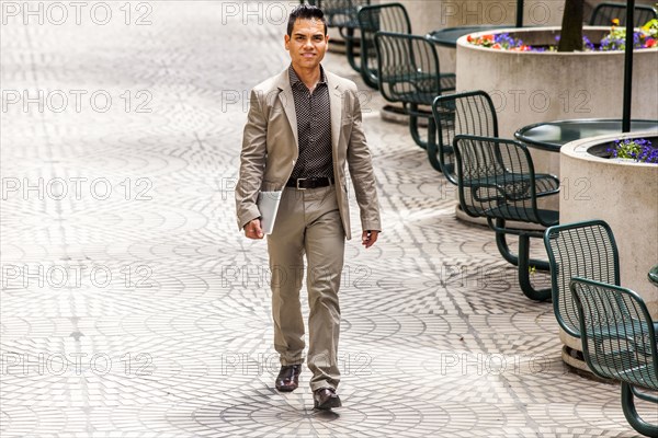 Hispanic businessman walking in courtyard