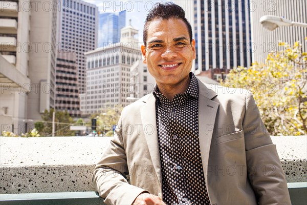 Hispanic businessman smiling in city